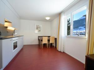 eine Küche und ein Esszimmer mit einem Tisch und einem Fenster in der Unterkunft Apartment Surses Alpin-1 by Interhome in Savognin