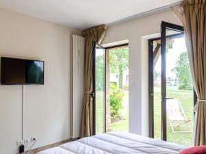 a bedroom with a bed and a sliding glass door at Apartment Les Hauts de Deauville-2 by Interhome in Tourgeville