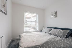 a white bedroom with a bed and a window at Central 2 double bedroom flat with parking in Bournemouth
