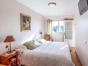 a white bedroom with a bed and a window at Apartment Le Hoc-1 by Interhome in Deauville