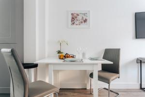a white dining room table with two chairs at Central 2 double bedroom flat with parking in Bournemouth