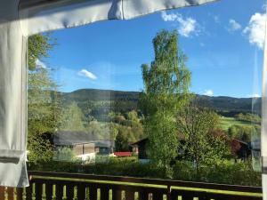 een raam met uitzicht op een huis en een boom bij Apartment Am Hohen Bogen-16 by Interhome in Arrach