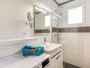 a white bathroom with a sink and a mirror at Apartment Le Zal-2 by Interhome in Quiberon