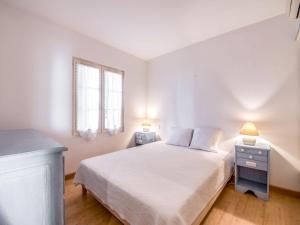 a white bedroom with a bed and two night stands at Apartment Boulevard Louis Blanc-1 by Interhome in Saint-Tropez