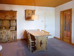 a dining room with a wooden table and wooden cabinets at Apartment Montagnards 17 by Interhome in Villars-sur-Ollon