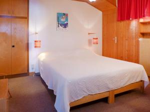 1 cama blanca grande en un dormitorio con cortina roja en Apartment Montagnards 17 by Interhome, en Villars-sur-Ollon