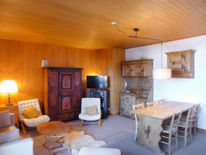sala de estar con techo de madera, mesa y sillas en Apartment Montagnards 17 by Interhome, en Villars-sur-Ollon