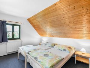 una camera da letto con due letti e soffitto in legno di Holiday Home Holiday Hill 33 by Interhome a Lauterwasser