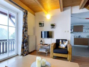 salon z kanapą, krzesłem i telewizorem w obiekcie Holiday Home Holiday Hill 44 by Interhome w mieście Lauterwasser