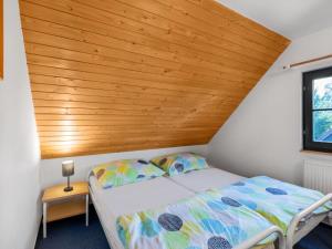 a bed in a room with a wooden ceiling at Holiday Home Holiday Hill 51 by Interhome in Lauterwasser