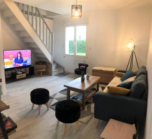 a living room with a couch and a tv at Gîte des vignes in Précigné