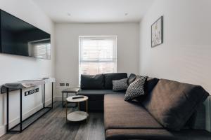 a living room with a couch and a table at Central 2 double bedroom flat with parking in Bournemouth