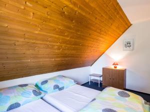ein Bett in einem Zimmer mit Holzdecke in der Unterkunft Holiday Home Holiday Hill 38 by Interhome in Lauterwasser