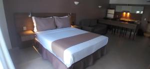 a bedroom with a large white bed and a desk at Wind e Blue in Jericoacoara