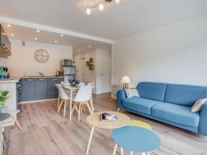 キブロンにあるApartment Les Gemeaux-6 by Interhomeの青いソファとキッチンのあるリビングルーム