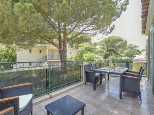 eine Terrasse mit einem Tisch und Stühlen auf dem Balkon in der Unterkunft Apartment Le Jardin d'Artemis-2 by Interhome in Saint-Tropez