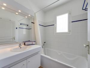 ein weißes Badezimmer mit einem Waschbecken und einer Badewanne in der Unterkunft Apartment Le Jardin d'Artemis-2 by Interhome in Saint-Tropez