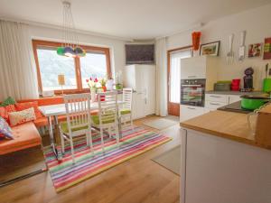kuchnia i salon ze stołem i krzesłami w obiekcie Apartment Milli by Interhome w mieście Wenns