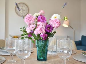 um vaso de flores sentado numa mesa com copos em Apartment Les Arts-1 by Interhome em Deauville