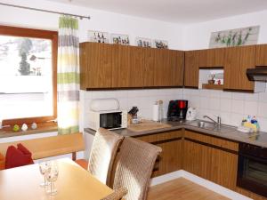 ヴェンスにあるApartment Walter by Interhomeのキッチン(木製キャビネット、テーブル、椅子付)