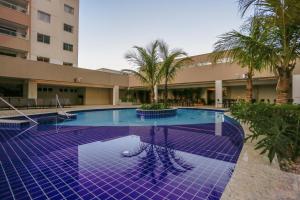 una gran piscina con baldosas púrpuras en un edificio en Enjoy Olimpia Park Resort, en Olímpia