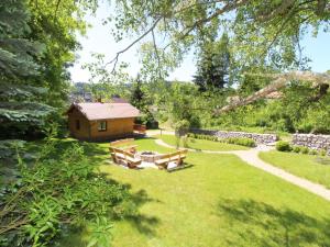 a garden with a log cabin and a stone wall at Chalet Bečov nad Teplou 1 by Interhome in Bečov nad Teplou