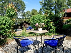 two chairs and a table with a vase on it at Apartment Ferienpark Himmelberg-3 by Interhome in Thalfang