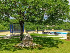 un parque con un árbol y una piscina en Holiday Home Villa Aniva by Interhome en Žminj