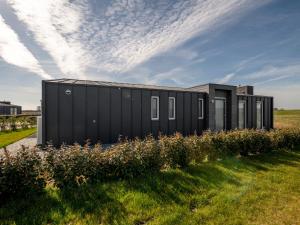 a black shipping container in a field of grass at Holiday Home Ruisweg 55 by Interhome in Wemeldinge