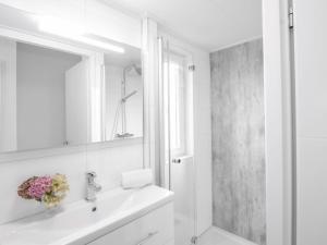 een witte badkamer met een wastafel en een spiegel bij Holiday Home Vakantiehuis Ruisweg 55 by Interhome in Wemeldinge