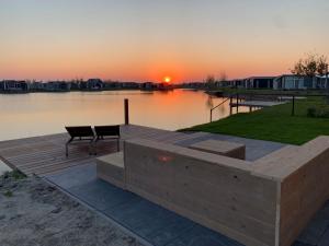 a sunset over a body of water with a dock at Holiday Home Vakantiehuis Ruisweg 62 by Interhome in Wemeldinge