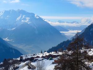 a snow covered mountain range with a village in the foreground at Apartment Royal 4 by Interhome in Verbier