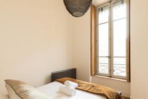 een slaapkamer met een bed en een raam bij DIFY Bellecour - Centre Ville in Lyon