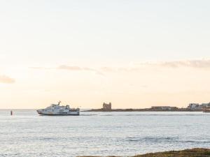 um barco na água com um castelo ao fundo em Studio Les Trois Iles-8 by Interhome em Quiberon