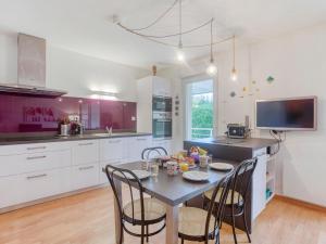 eine Küche mit einem Tisch mit Stühlen und einem TV in der Unterkunft Apartment Résidence Sainte Anne by Interhome in Quiberon
