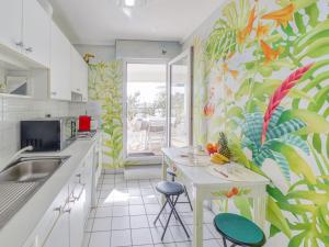 una cucina con un murale tropicale sul muro di Apartment Les Jardins Victoria-1 by Interhome a Biarritz