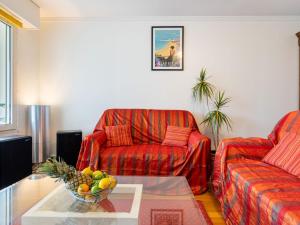 un soggiorno con 2 divani rossi e un tavolo di Apartment Les Jardins Victoria-1 by Interhome a Biarritz