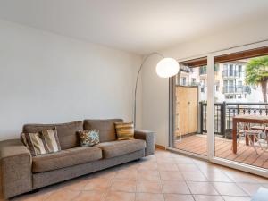 een woonkamer met een bank en een balkon bij Apartment Tasman 15-R by Interhome in Bouveret
