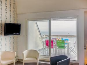 ein Wohnzimmer mit einer Glasschiebetür und einem Balkon in der Unterkunft Apartment Résidence Kerentrech-4 by Interhome in Quiberon