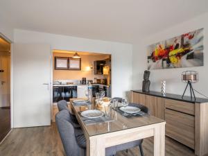 a dining room with a wooden table and chairs at Apartment Les grands jardins by Interhome in Saint Malo
