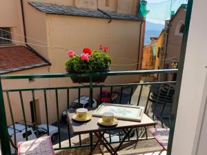 a balcony with a table and flowers on a balcony at Holiday Home Arietta VLO150 by Interhome in Valloria