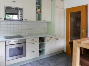 a kitchen with white cabinets and a stove at Holiday Home Peenetal by Interhome 