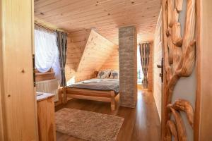 una camera da letto con un letto in una cabina di legno di Tatrzanskie domki a Poronin