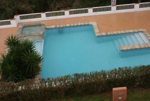 a large blue swimming pool next to a building at EL MIRADOR in Alaior