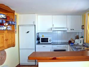 uma cozinha com armários brancos e um frigorífico branco em EL MIRADOR em Alaior