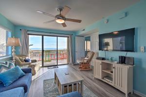a living room with a couch and a tv at Ocean-View Condo with Deck, Steps to Carolina Beach! in Carolina Beach