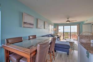 a living room with a table and a couch at Ocean-View Condo with Deck, Steps to Carolina Beach! in Carolina Beach