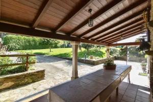 a patio with a wooden pergola and a table at Casa Compostela in Bama