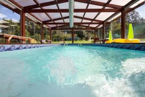 a large swimming pool with a wooden pergola at Casa Compostela in Bama