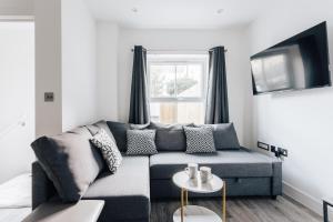 a living room with a couch and a window at Contemporary Two Bedroom Duplex - Secluded Residence with Parking in a Prime Central Location in Bournemouth